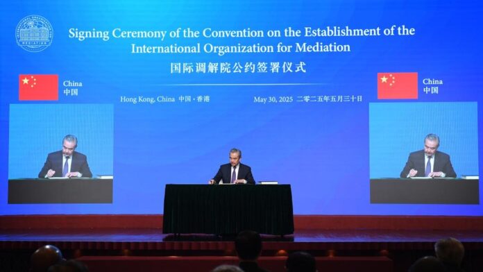 Chinese Foreign Minister Wang Yi speaks at the signing ceremony of the Convention on the Establishment of the International Organization for Mediation in Hong Kong May 30